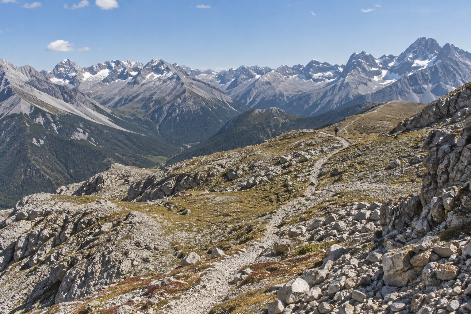 High alpine pass trail above Il Fuorn with rocky terrain and distant peaks